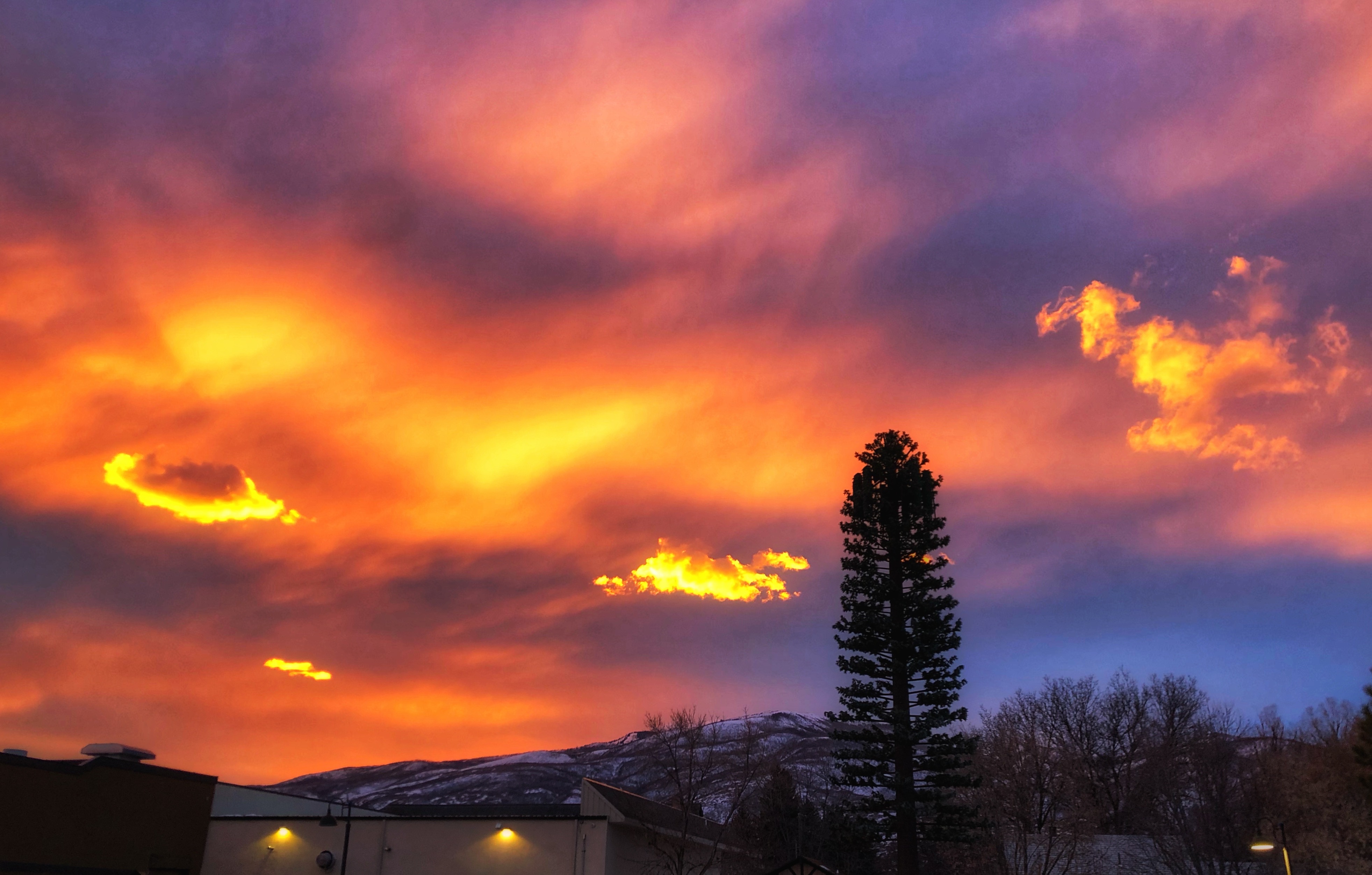 A Utah sunset finds its way between the heavy laye...